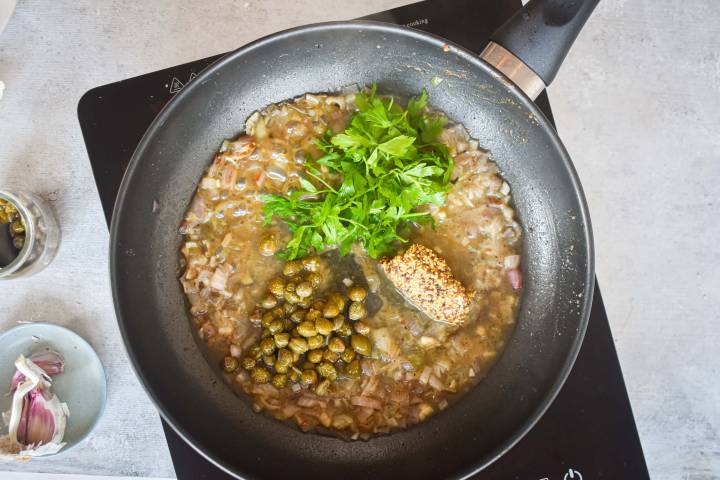 Mustard, parsley, and capers simmering in a piccata sauce.