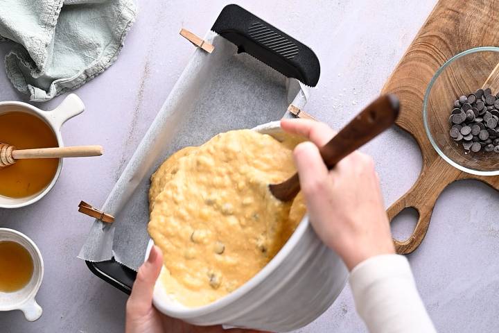 Pumpkin batter being poured into a bread pan.