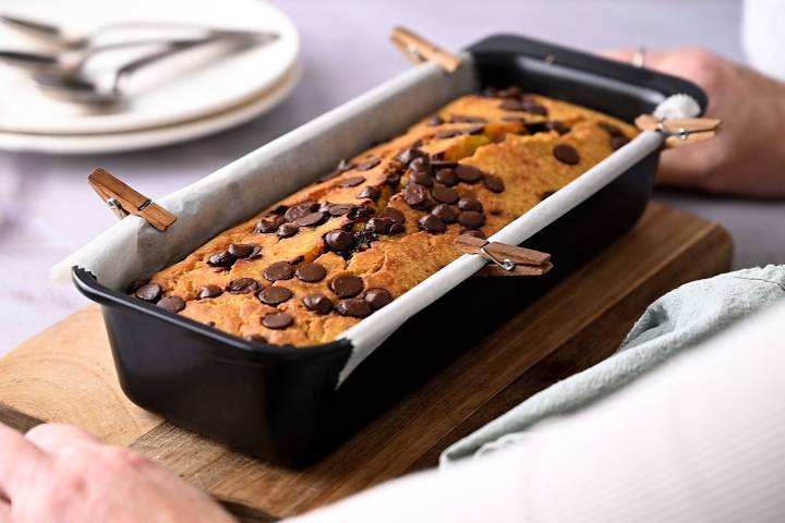 Baked pumpkin bread in a bread pan with chocolate chips.