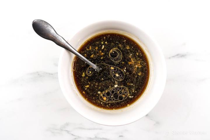 Sesame chicken sauce in a bowl with a spoon.