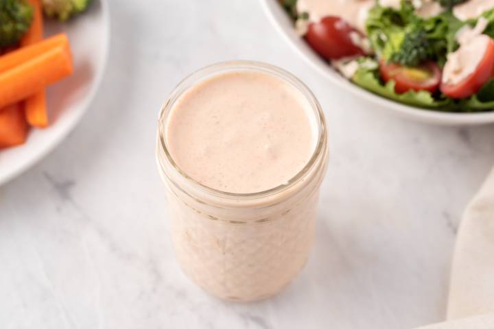 Yogurt thousand island dressing stored in a glass jar.