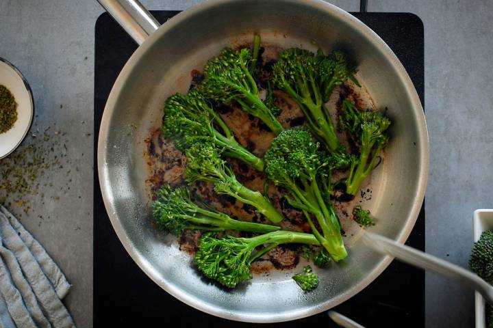 Broccolini being cooked in a skillet.
