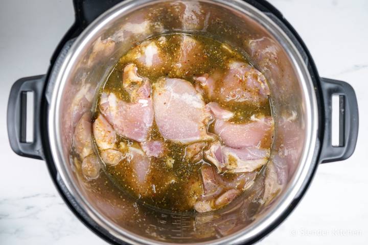 Chicken thighs and green salsa in an Instant pot.