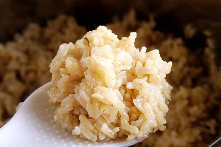 Cooked brown rice in an Instant Pot on a spoon.