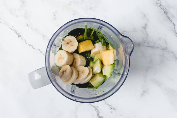 Mango, baby spinach, banana, and avocado in a blender. 
