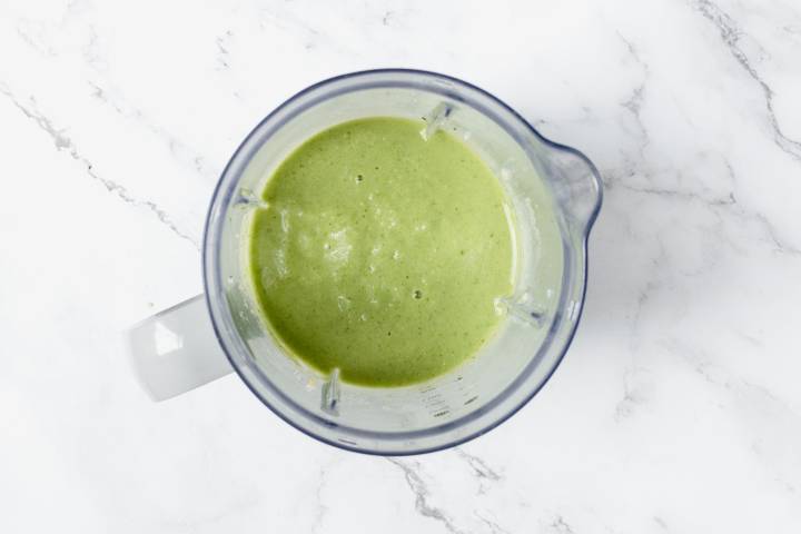 Blended mango spinach green smoothie in a blender. 