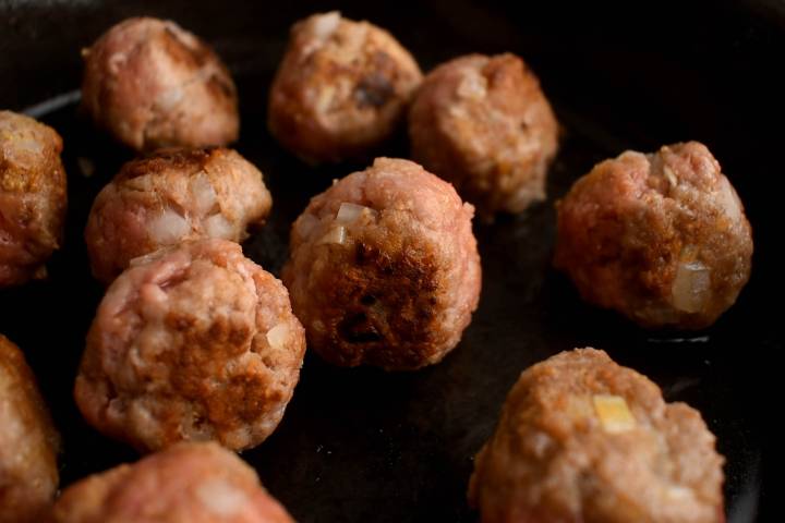 Mexican meatballs being browned in a skillet.