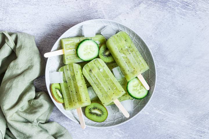 Cucumber paletas on a plate with ice cubes.