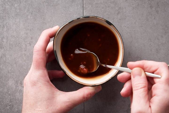 Mongolian stir fry sauce being stirred in a small bowl.