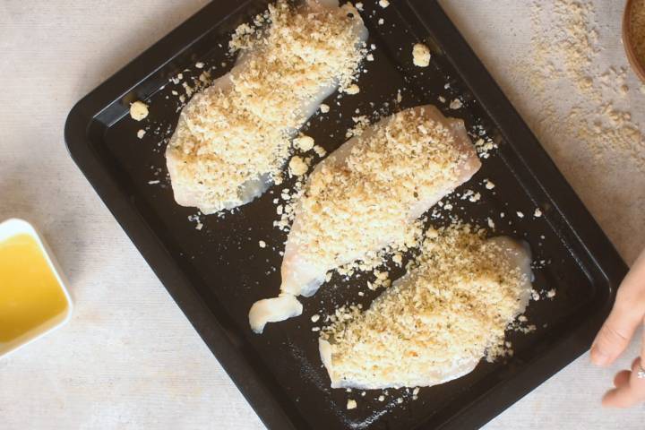 Panko and Parmesan coating on tilapia in a baking dish.