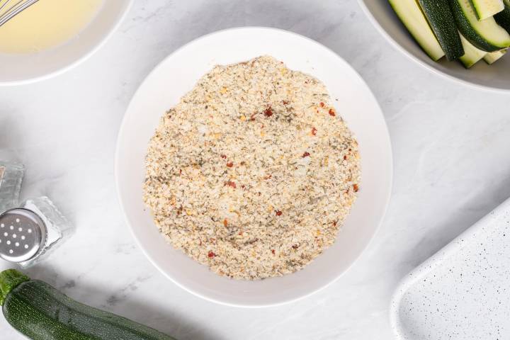 Panko breadcrumbs, Parmesan cheese, and spices on a shallow plate.