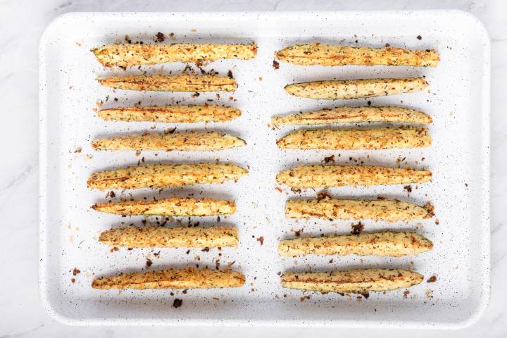 Baked zucchini fries on a baking sheet.
