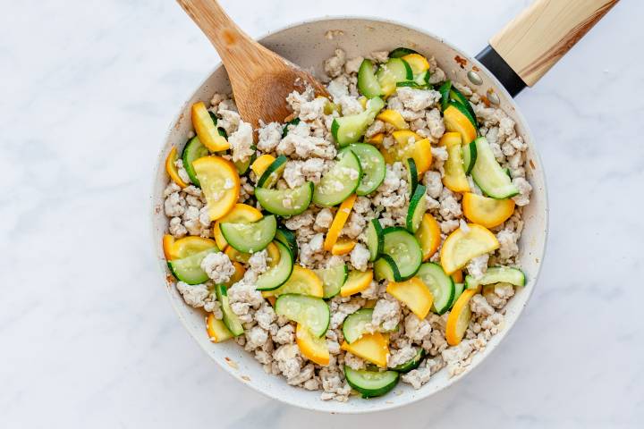 Zucchini, yellow squash, and ground turkey in a skillet.