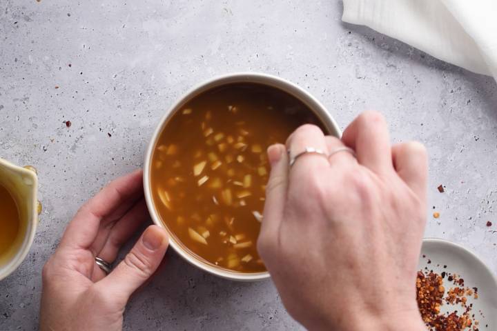 Pineapple stir fry sauce being stirred in a small bowl.