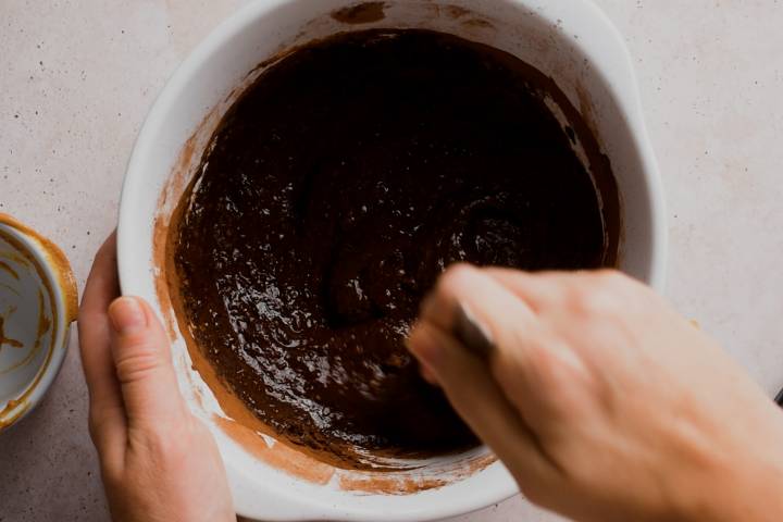 Pumpkin brownie batter being mixed in a bowl.