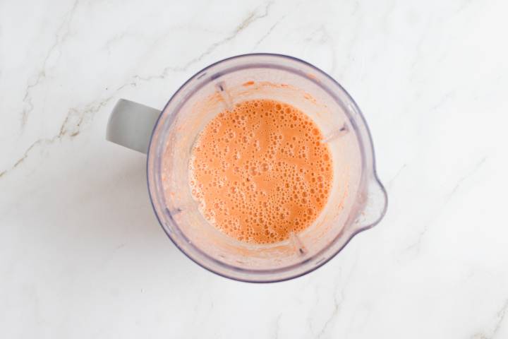 Carrots and almond milk blended in a blender.