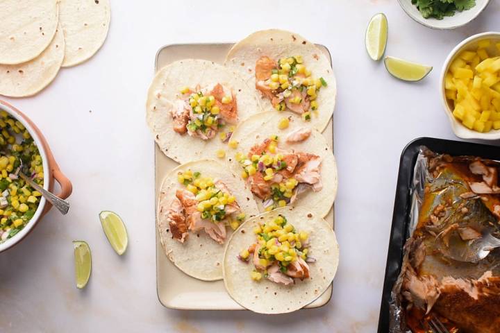 Salmon tacos on a tray with corn salsa. 