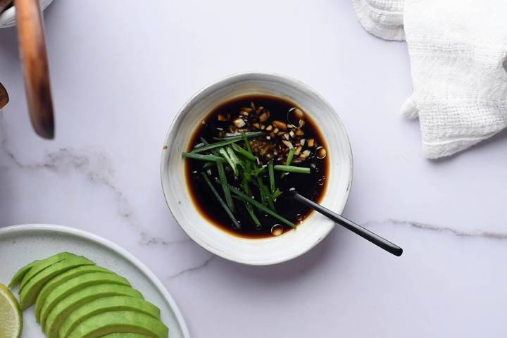 Soy sauce, sesame oil, rice vinegar, honey, ginger, garlic, and green onions in a bowl.