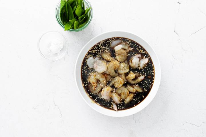 Shrimp marinating in homemade sesame sauce in a bowl.