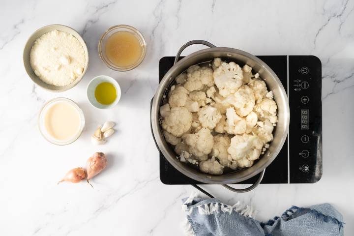 Cauliflower being cooked in a pot of boiling water.