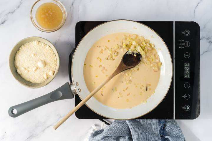Shallots, garlic, and evaporated milk in a saute pan.