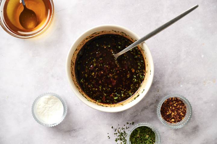Soy sauce, ketchup, dried basil, honey, and garlic in a small bowl.