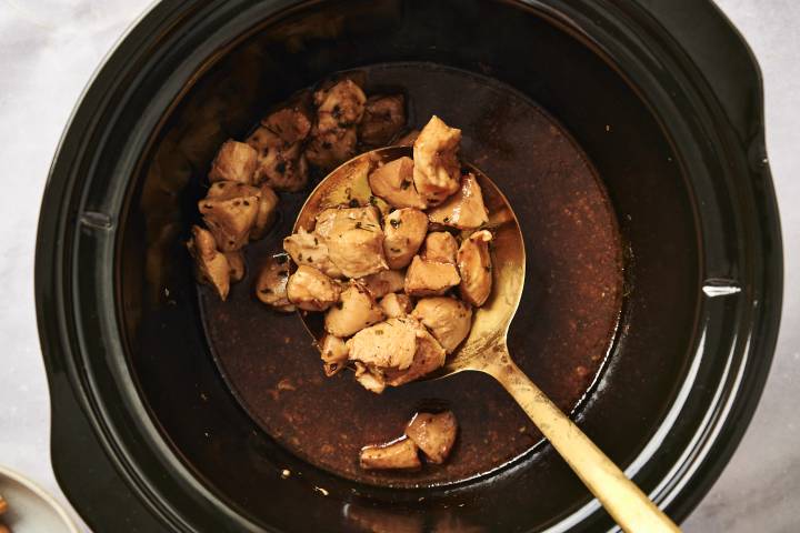Cooked chicken breast in a slow cooker with honey garlic sauce.