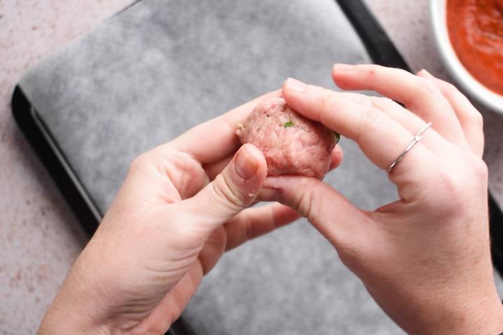 Tow hands forming a turkey meatball.