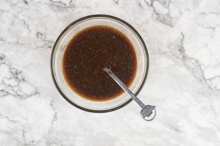 Soy sauce, chicken broth, rice vinegar, and cornstarch in a small glass bowl.