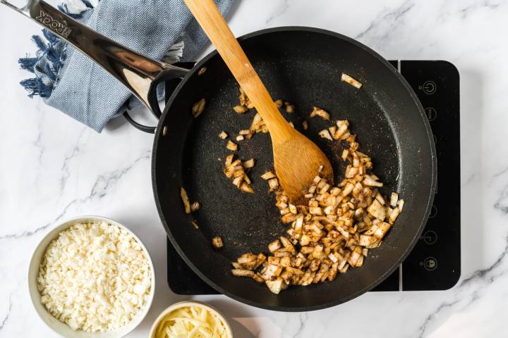 Onion being sautéed with taco seasoning in a skillet.