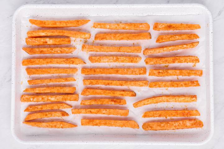 Baking sheet with uncooked sweet potato fries.
