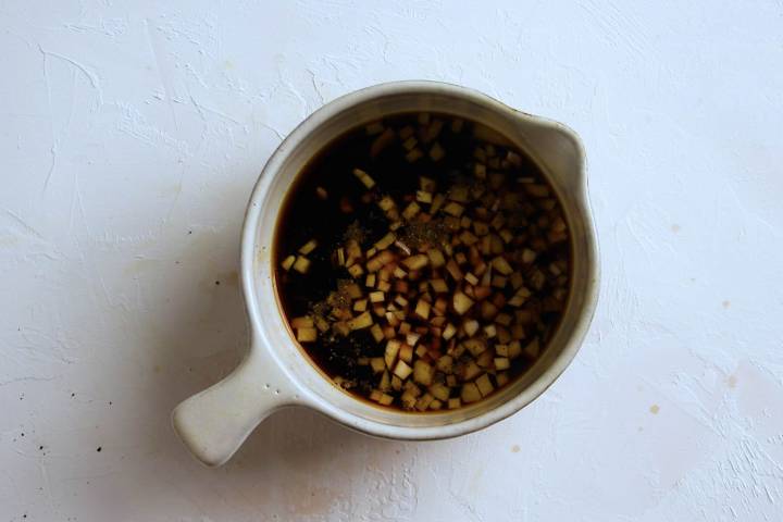 Teriyaki marinade with soy sauce, garlic, ginger, honey, and rice vinegar in a bowl.