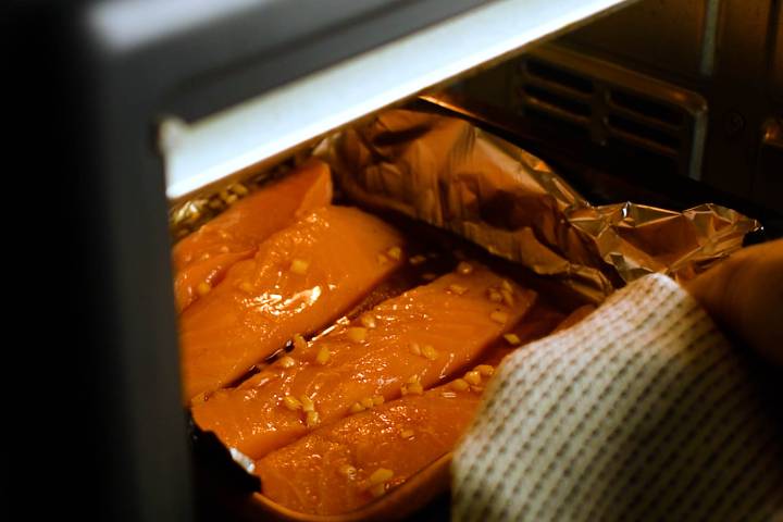 Salmon baking in foil in the oven.