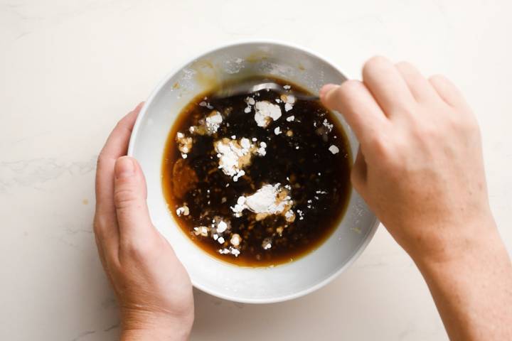 Teriyaki sauce being stirred with cornstarch in a bowl.