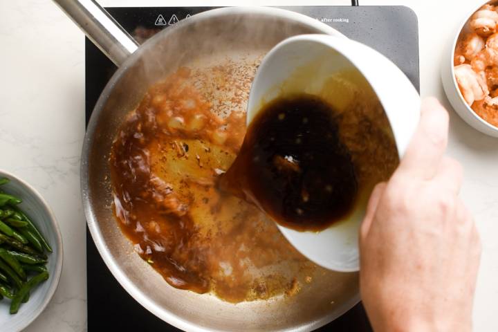 Teriyaki sauce reducing in a skillet.