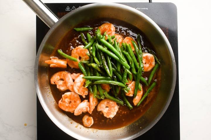 Teriyaki shrimp and green beans in a pan. 
