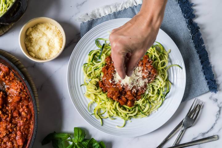 Zucchini noodles with turkey tomato basil sauce with parmesan cheese bring sprinkled on top.