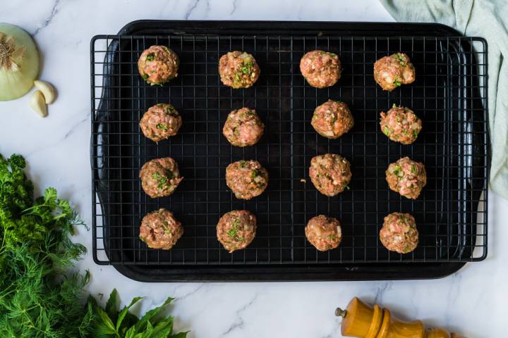 Ground beef and lamb meatballs on a wire rack.