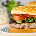 Chicken caesar burger with lettuce and tomato on a bun.