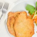 Honey mustard pork with a light breading on a plate with salad.