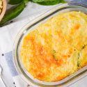 Spaghetti squash gratin in a glass baking dish with parmesan cheese and basil.