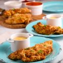 Air fryer chicken tenders with honey mustard sauce on two blue plates. 