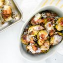 Bacon Brussel Sprouts with Parmesan cheese in a dish with a baking sheet.