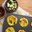 Bacon, zucchini, and cheese egg muffins in a muffin tin. 