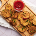 Eggplant cutlets coated in breadcrumbs on a plate with fresh herbs.