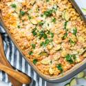 Baked zucchini pasta in a baking dish with melted cheese and zucchini slices.
