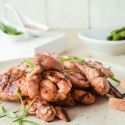 Broiled Asian Chicken Thighs with chopsticks, green onions, and sesame seeds.