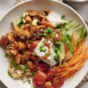 Buffalo chicken bowls with cauliflower, rice, carrots, cucumber, cherry tomatoes, buffalo sauce, and blue cheese dressing.