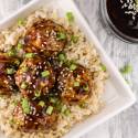 Chicken Teriyaki Meatballs on a bed of brown rice with green onions.