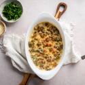 Creamed kale with tender kale cooked with cream cheese, milk, and Parmesan cheese in a white baking dish,